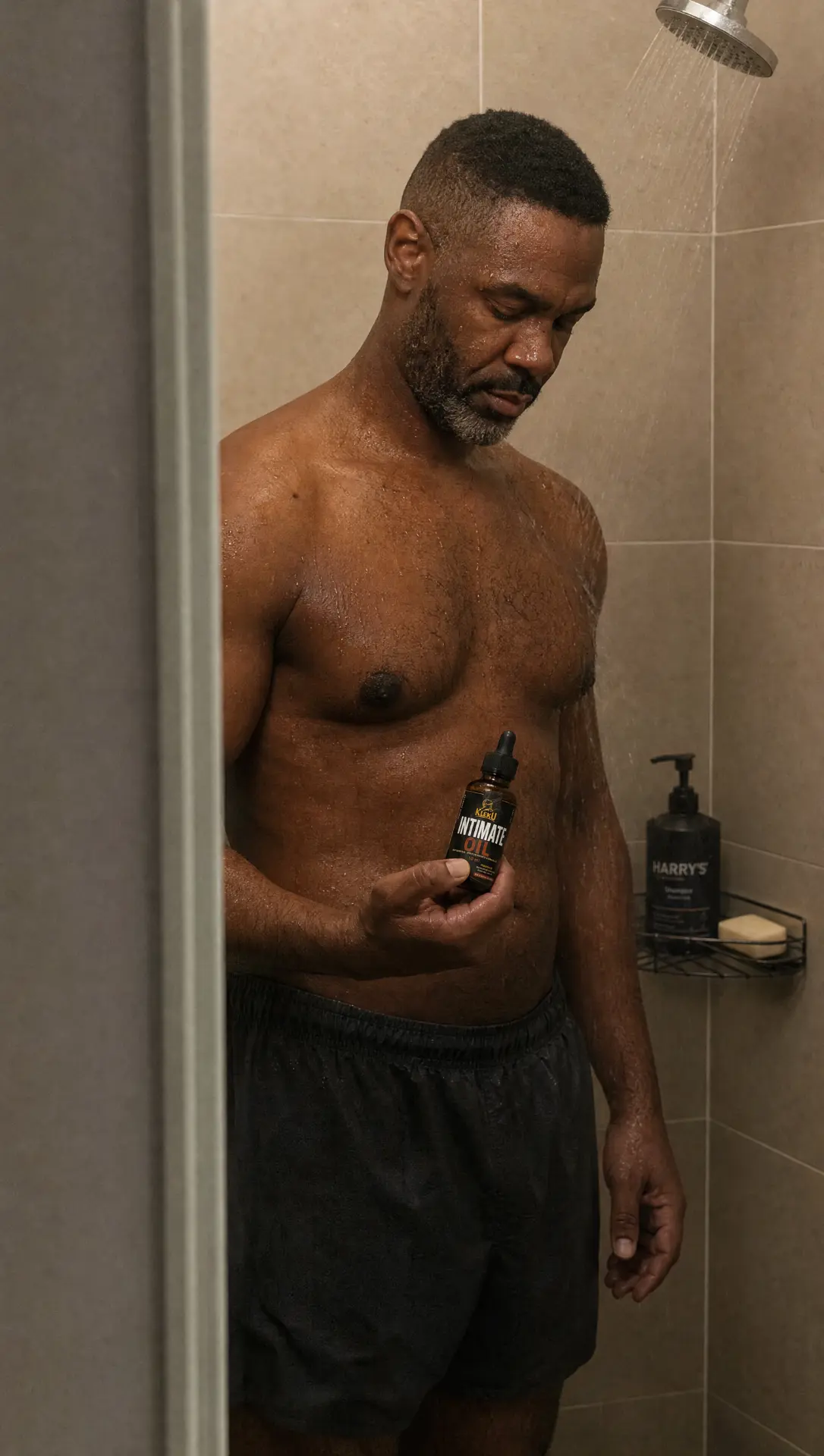 Customer holding Kleku Intimate Oil during his shower routine