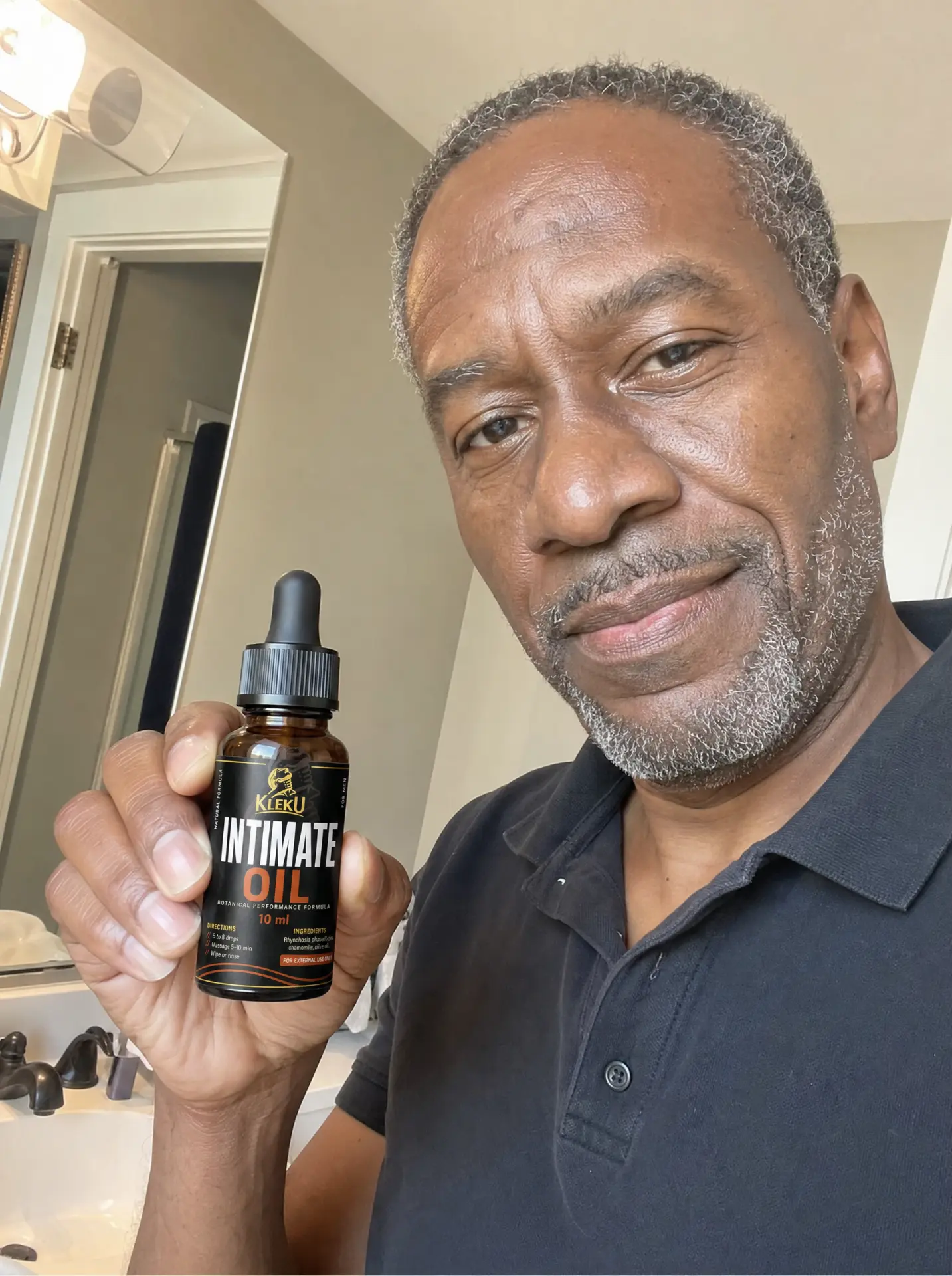 Verified customer holding his Kleku Intimate Oil bottle