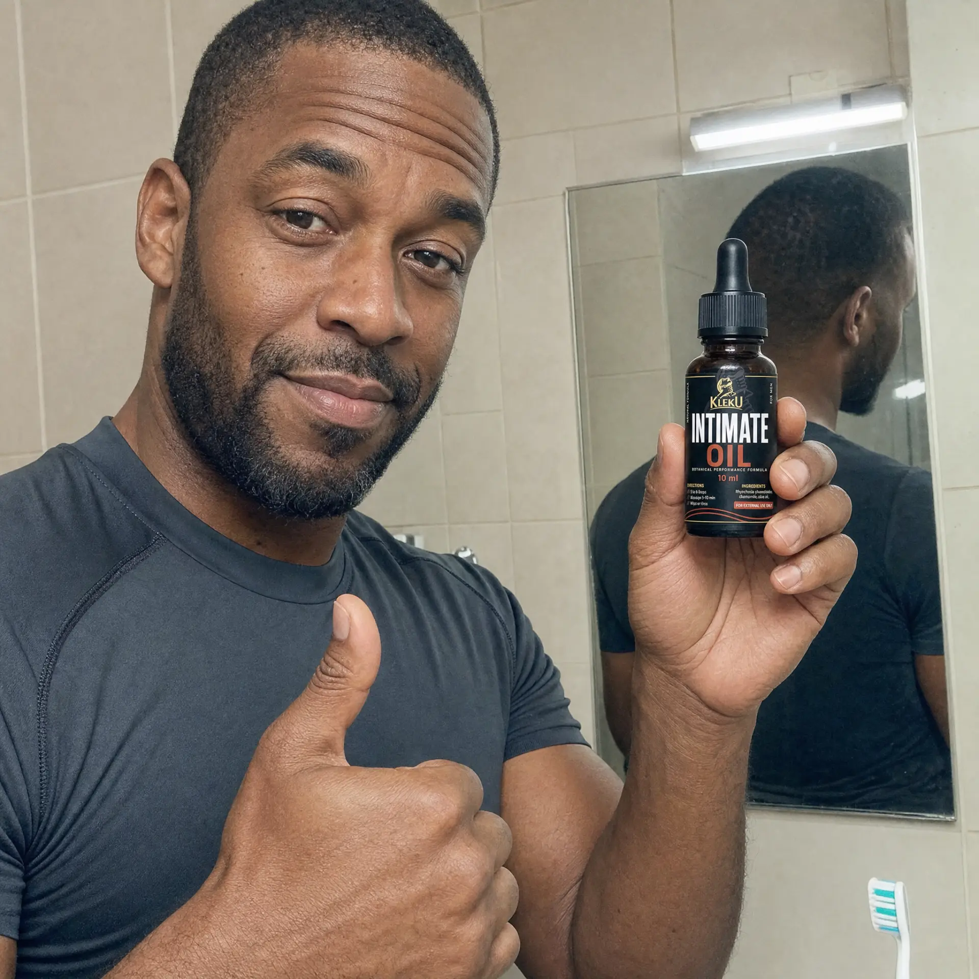 Man giving a thumbs-up while holding a Kleku Intimate Oil bottle in a bathroom